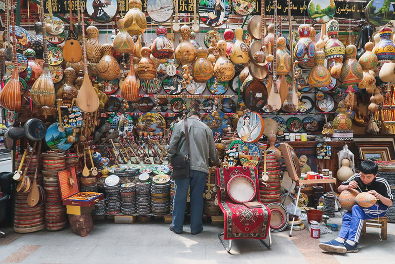 A man browsing the wares of a stall at the Urumqi Grand Bazaar in China